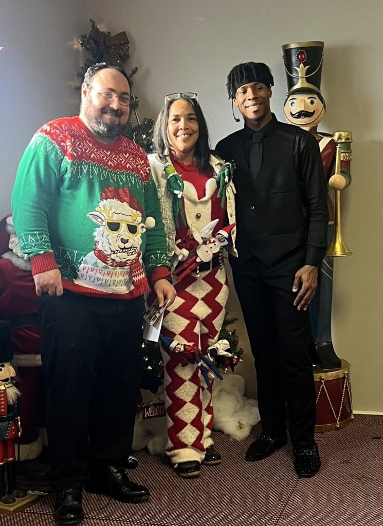 Ronda Brodhead (center) surrounded by two individuals we support at our Holiday Party 2024