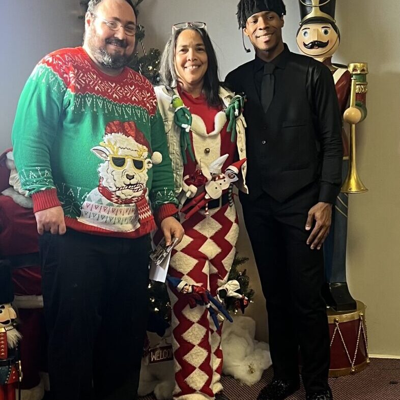 Ronda Brodhead (center) surrounded by two individuals we support at our Holiday Party 2024